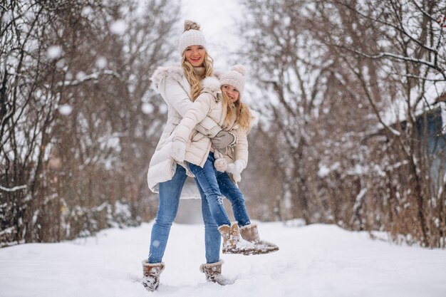 Mother with daughter walking together in a winter park