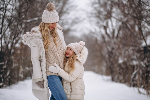 Мать с дочерью гуляют вместе в зимнем парке