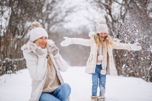 Мать с дочерью гуляют вместе в зимнем парке