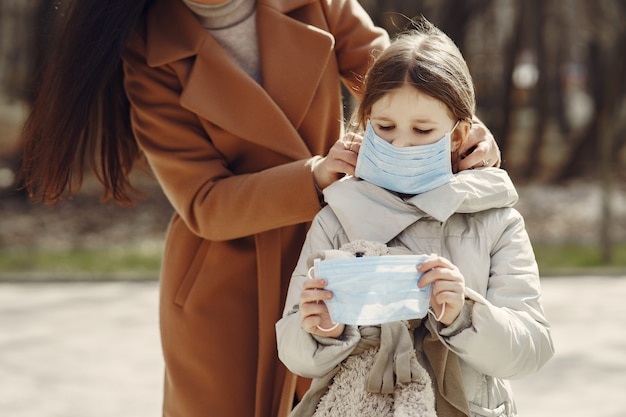 Mother with daughter walks outside in masks