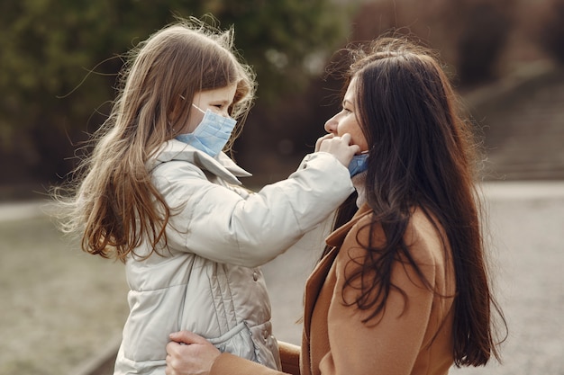 Mother with daughter walks outside in masks