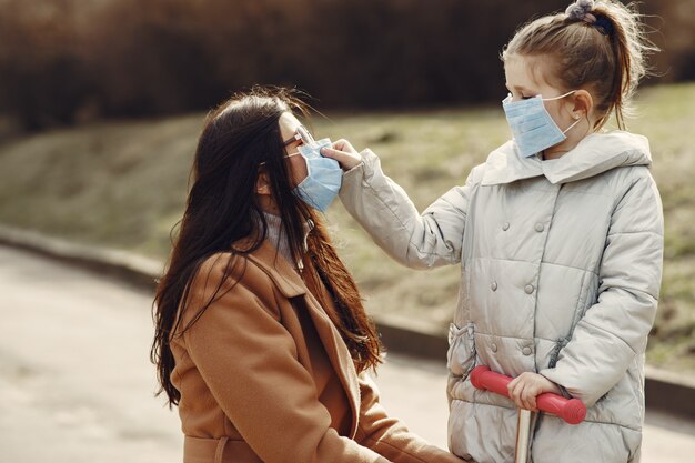 Mother with daughter walks outside in masks