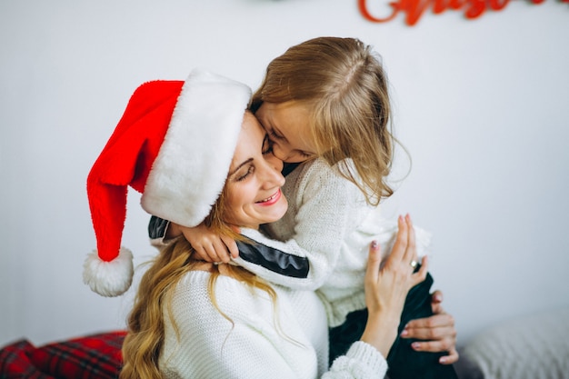 Mother with daughter wearing christmas hat