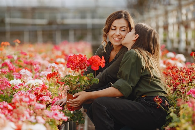 Mother with daughter. Workers with flowerpoots. Girl in a green shirt