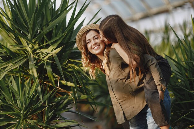 Foto gratuita madre con figlia. lavoratori con fioriere. ragazza in una camicia verde