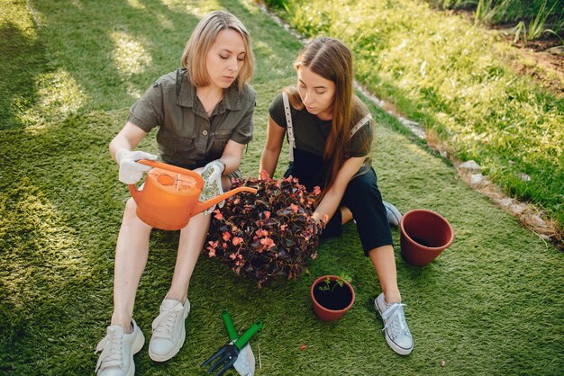 mother with a daughter works in a garden near the house