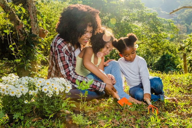 Mother with daughters sitting on the grass