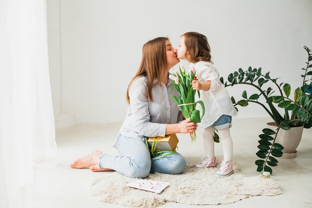 花と娘のキスを持つ母