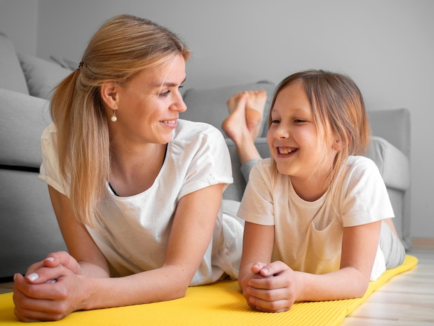 Mother with girl practice on mat