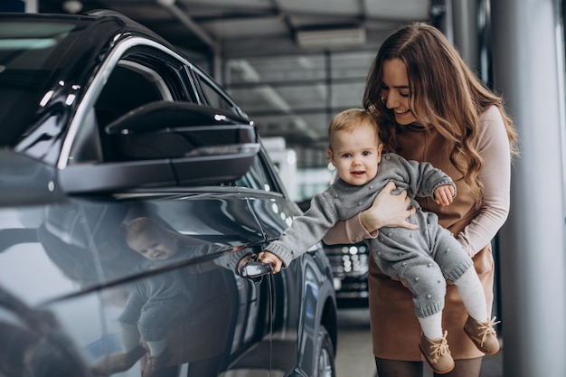 Mother with her baby daughter in a car showroom