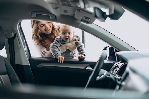 Mother with her baby daughter in a car showroom