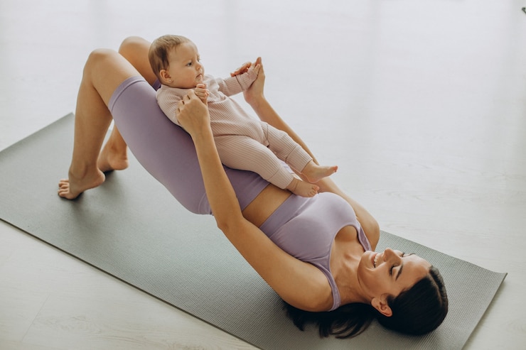 Mother with her baby daughter practice yoga at home
