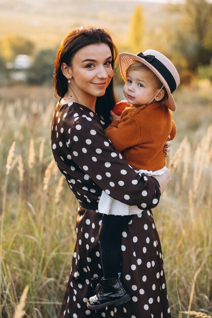Mother with her baby girl in an autumn field