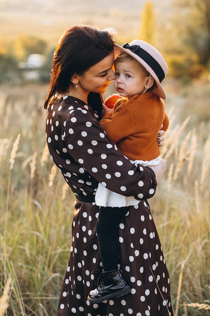 Mother with her baby girl in an autumn field