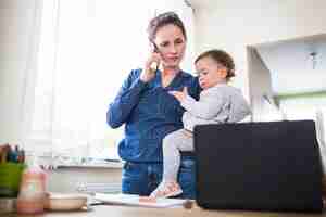 Foto gratuita madre con il suo bambino parlando su smartphone