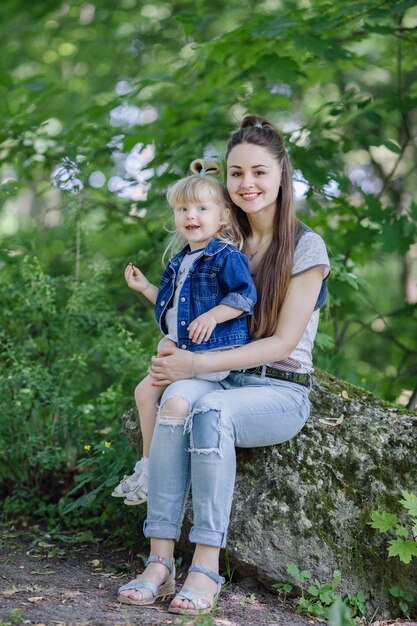 Mother with her daughter sitting on her knees