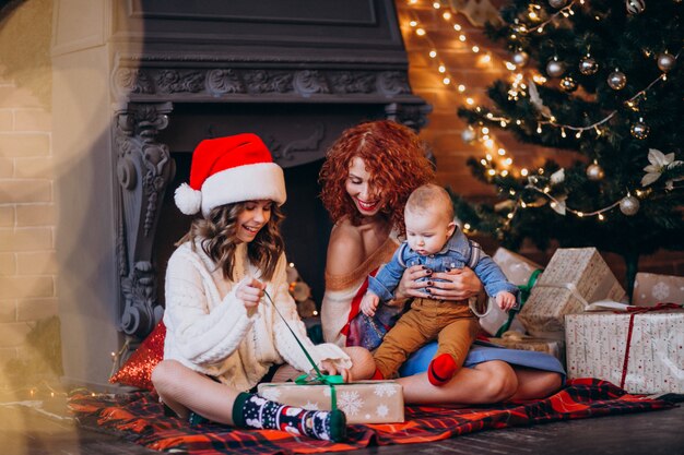 彼女の娘とクリスマスツリーによるクリスマスに息子を持つ母