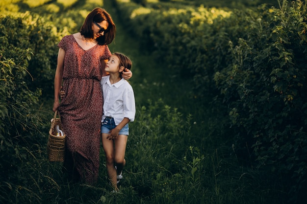 Madre con sua figlia che cammina in un campo verde