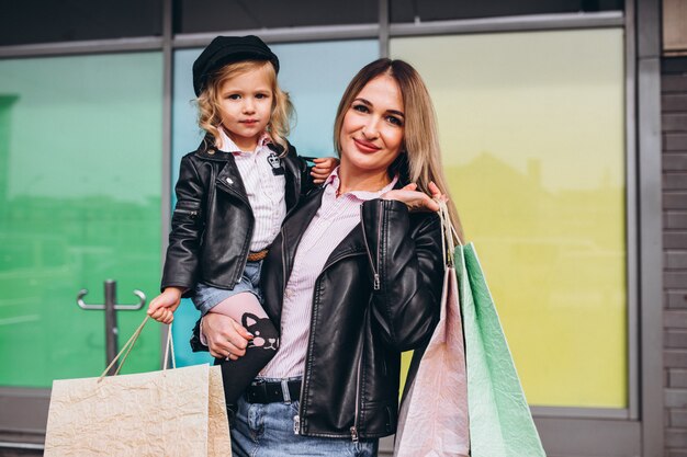 Mother with her little cute daughter with shopping bags