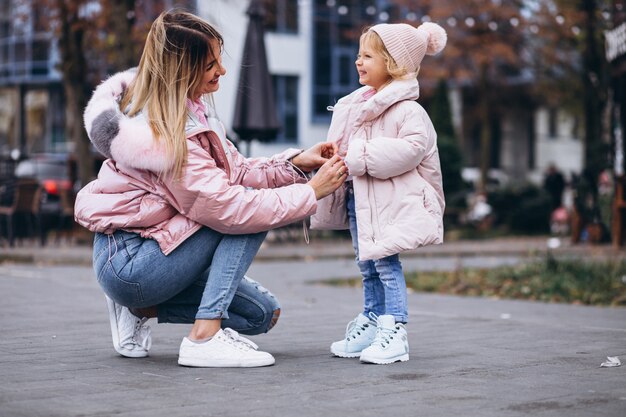거리 밖에서 따뜻한 헝겊을 입고 그녀의 어린 딸과 어머니