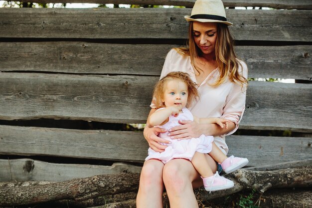 Mother with her little daughter sitting on her legs