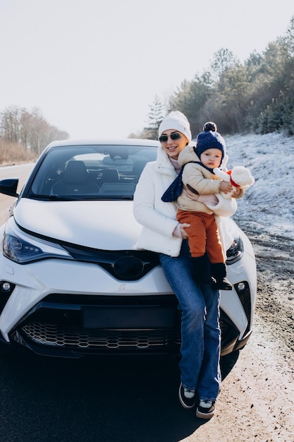 Free photo mother with her little son by the car