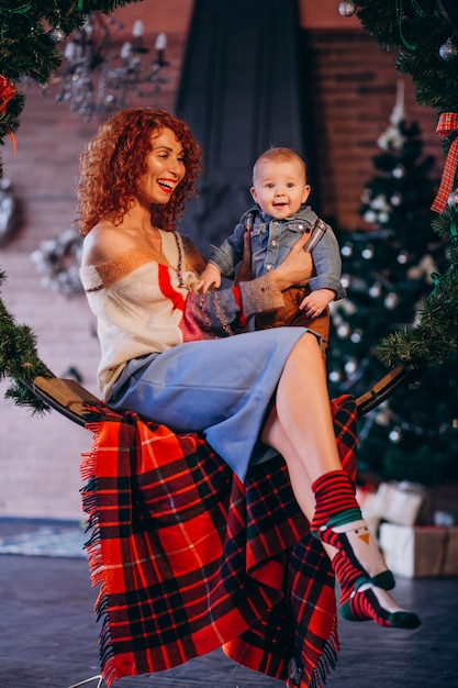 Free photo mother with her little son by the christmas tree