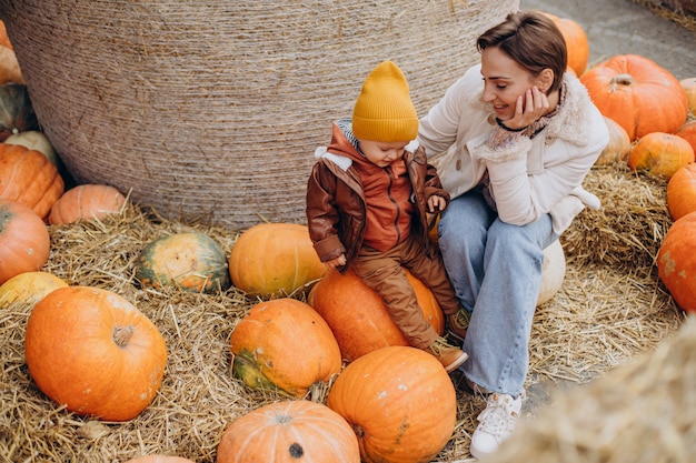 Mother with her little son by the pumpkins on halloween