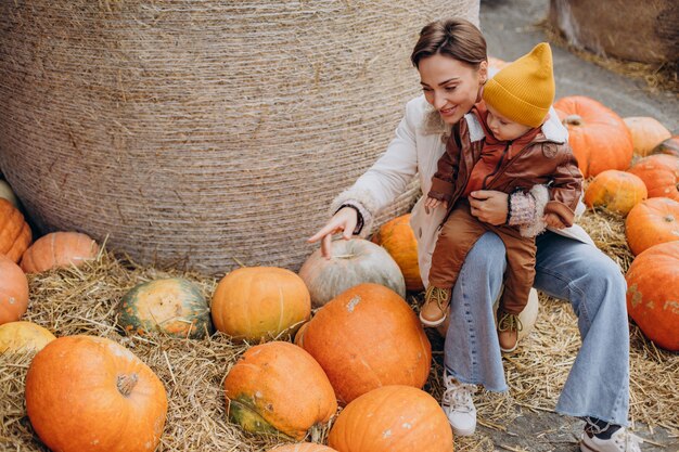 Mother with her little son by the pumpkins on halloween