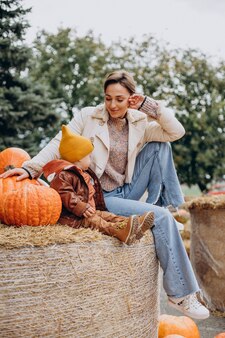 Mother with her little son by the pumpkins on halloween