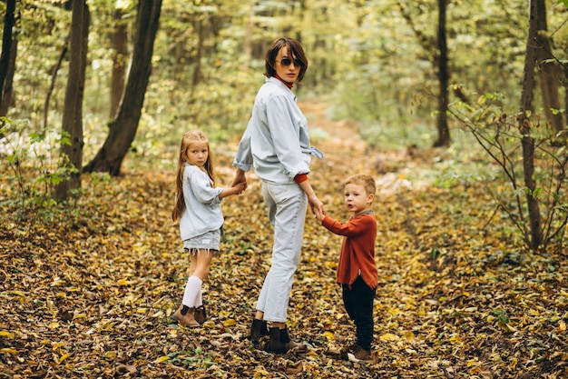 Madre con il suo piccolo figlio e figlia in un parco in autunno