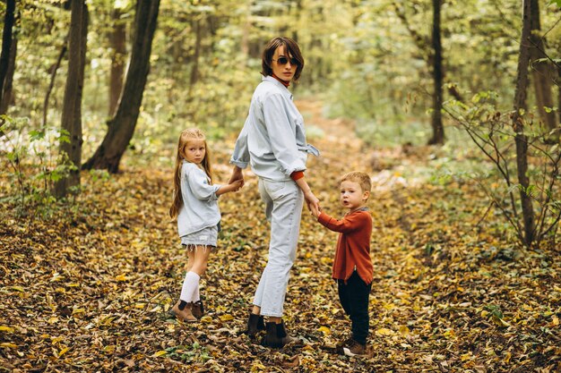 Mother with her little son and daughter in an autumn park