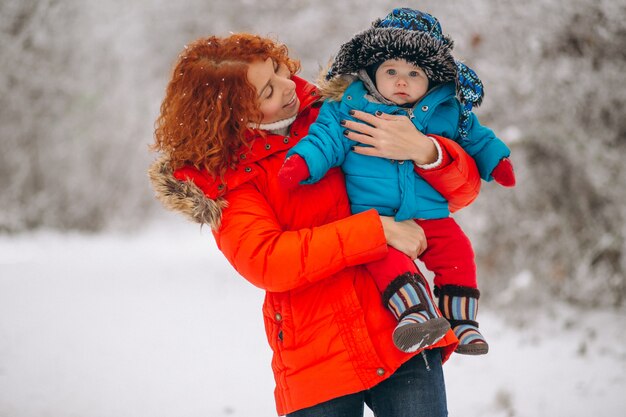 Mother with her little son together in a winter park