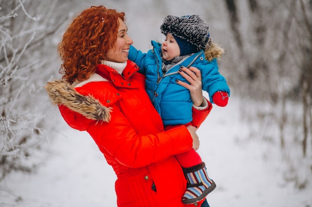 Madre con il suo piccolo figlio insieme in un parco d'inverno