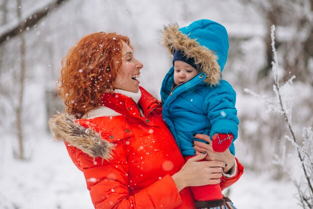 Madre con il suo piccolo figlio insieme in un parco d'inverno