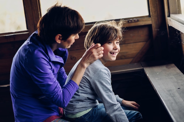 Mother with her seven year old daughter laughing in a cabin in the countryside. 