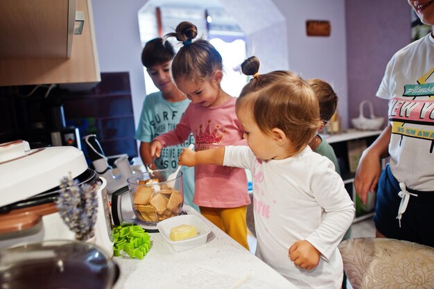 キッチンで料理をしている子供を持つ母親幸せな子供の瞬間