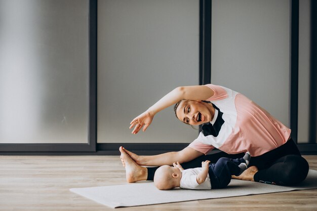 Mother with little baby boy practice yoga