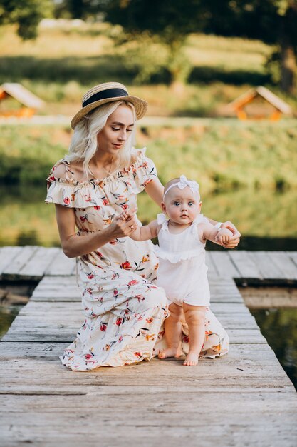 Mother with little baby daughter by the lake