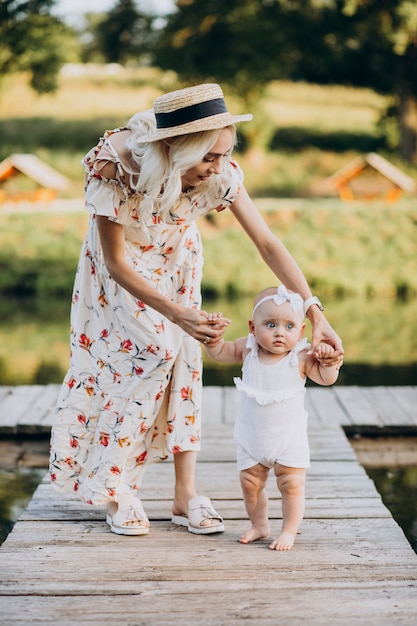 Mother with little baby daughter by the lake