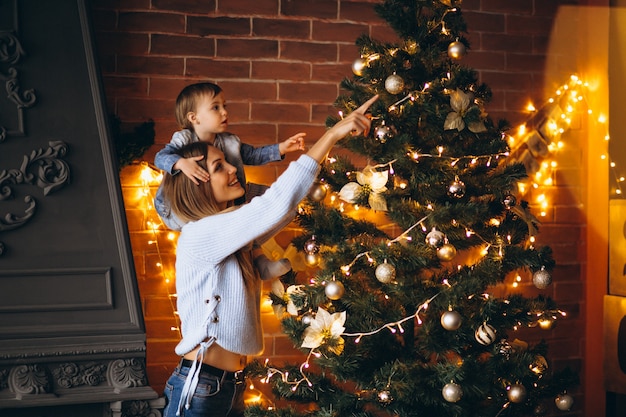 Mother with little daughter decorating Christmas tree