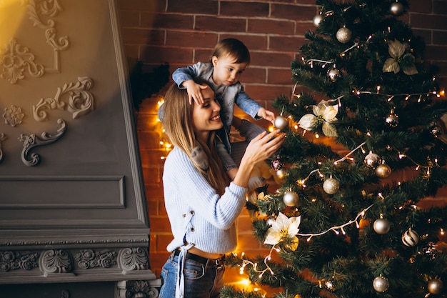 無料写真 クリスマスツリーを飾る小さな娘を持つ母