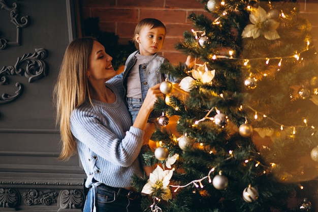 Mother with little daughter decorating Christmas tree