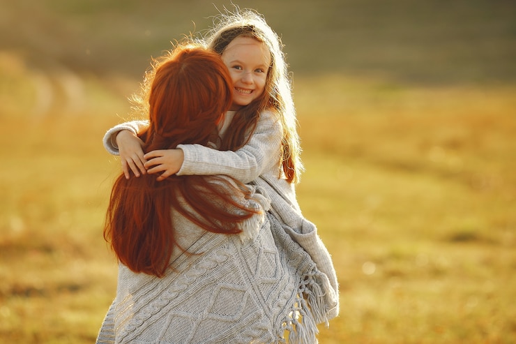 Free Photo mother with little daughter playing in a autumn field