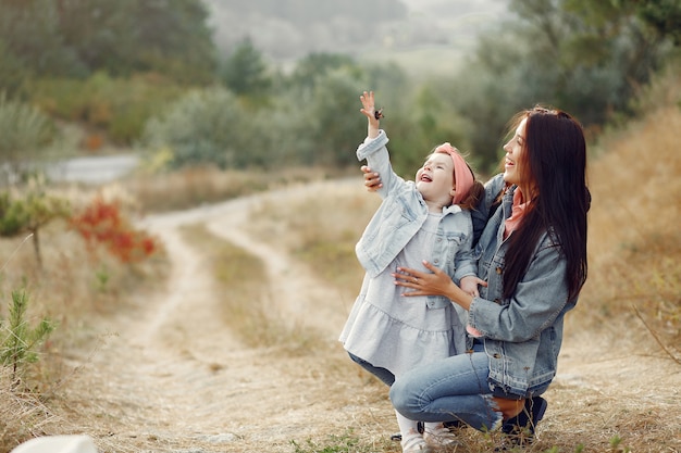 Mother with little daughter playing in a field