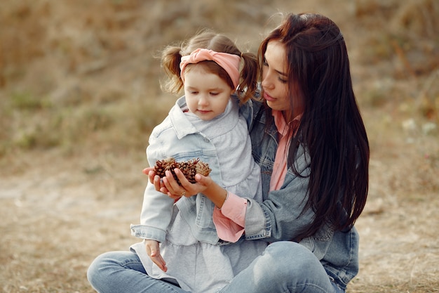 Foto gratuita madre con la piccola figlia che gioca in un campo