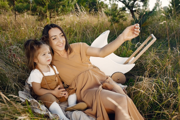 Mother with little daughter playing in a summer field