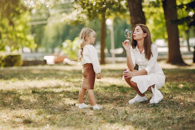 Мать с маленькой дочкой, играя в парке летом