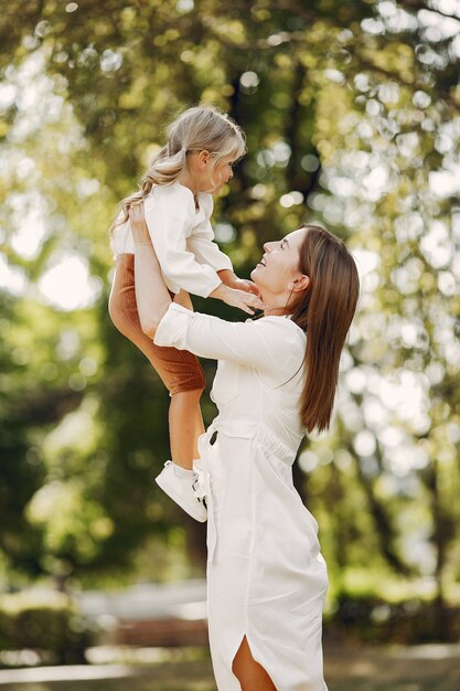 Mother with little daughter playing in a summer park