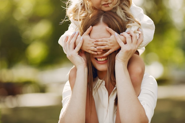 Mother with little daughter playing in a summer park